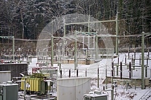 Electrical substation in winter with snow covered transformers and isolators