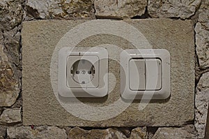 electrical switches and sockets mounted on a stone wall