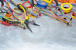 Electrical tools and component kit to use in electrical installations on grey metal background