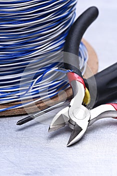 Electrical tools and component kit to use in electrical installations on grey metal background