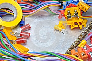 Electrical tools and component kit to use in electrical installations on grey metal background
