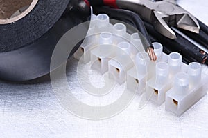 Electrical tools and component kit to use in electrical installations on grey metal background