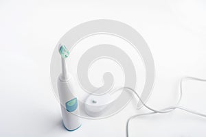 Electrical toothbrush with battery charger for higiene of mouth cavity on white background photo