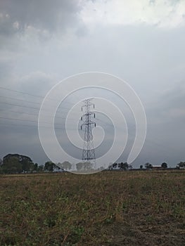 Electrical tower on field , cloudy sky background