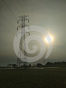 Electrical tower on field , cloudy sky background