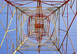 Electrical tower glowing in sunset colors seen from directly underneath