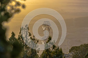 Electrical tower at sunset with foliage