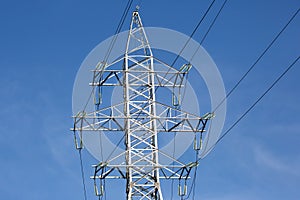 Electrical tower with voltage transmission wires against the background of blue sky. High voltage tower. power line support with