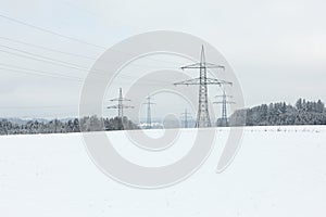 Electrical towers against white sky