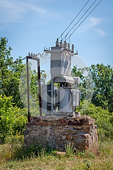 Electrical transformer on a stone stand. Old high-voltage power station.