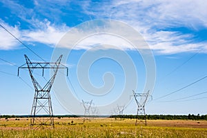Electrical transmission towers and power lines on fields