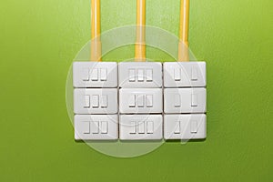 Electrical white rocker light switch on green wall