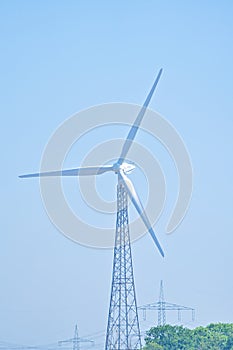 an electrical wind farm power energy production, wind turbine eco energy production in nature between the trees