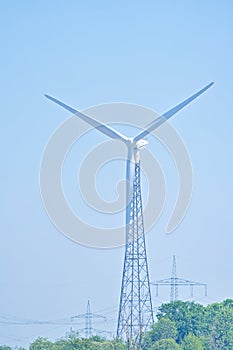 an electrical wind farm power energy production, wind turbine eco energy production in nature between the trees