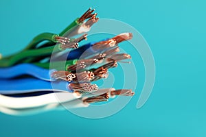 Electrical wires on light blue background, closeup. Space for text