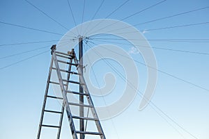 Electrical wiring on the roof of a high-rise building, a double staircase against the blue sky.