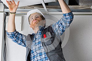 Electrical worker wiring in ceiling