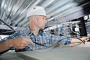electrical worker wiring in ceiling