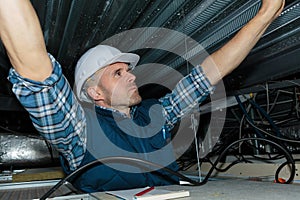 electrical worker wiring in ceiling