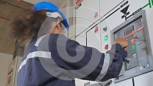 Electrical young asian woman engineer examining maintenance cabinet system electric and using tablet in control room.