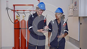 Electrical young woman and man engineer examining maintenance cabinet system electric in the control room.