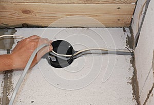 Electrican installing electrical wires in wall. Installation electrical wiring