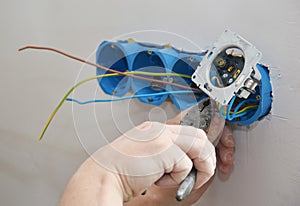 Electrican repair and installing socket boxes, outlet plug. Socket plug and plastic socket boxes installation in drywall