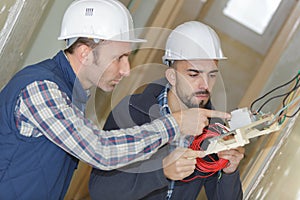 electrician with apprentice working in new home photo