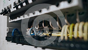 An electrician assembles an electrical panel in an apartment. Electrical box contains many terminals, relays, wires and