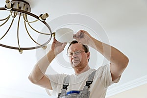 Electrician is attaching a plafond.