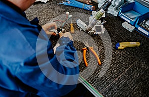 Electrician builder at work inspecting cabling connection of high voltage power electric line in industrial distribution fuseboard