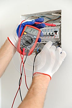 Electrician check voltage in electrical fuse box.