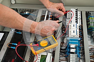 Electrician checking a fuse box photo