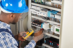 Electrician Checking Fuse Box With Multimeter