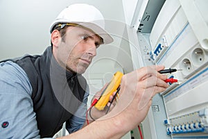 electrician checking voltage fuse board