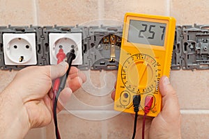 Electrician checking voltage in a partially installed electrical
