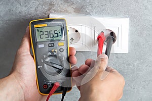 Electrician checking voltage in socket