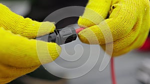 An electrician checks the wires. Special wire hardener at the power plant. An electrician in protective gloves installs