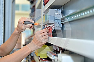 The electrician is connecting the electric cable wire