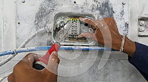 The electrician is connecting the power cable