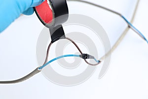 An electrician connects electrical wires using electrical leakage tape