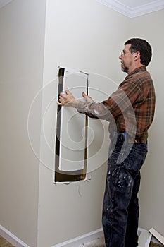 Electrician cutting access hole