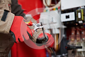 Electrician cutting cable with shear wire cutter photo