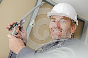 Electrician cutting cables in construction site