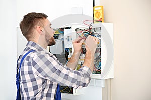 Electrician with digital multimeter checking voltage