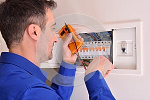 Electrician doing repairs in electrical housing box photo