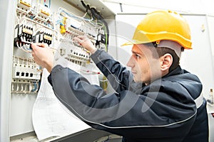 Electrician with drawing at power line box