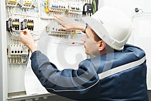Electrician with drawing at power line box