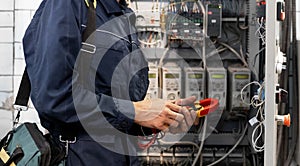 Electrician engineer checks electrical circuit in control panel for high current and voltage, starting and commissioning