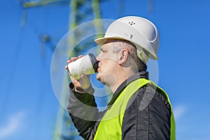 Electrician Engineer drink near high voltage tower